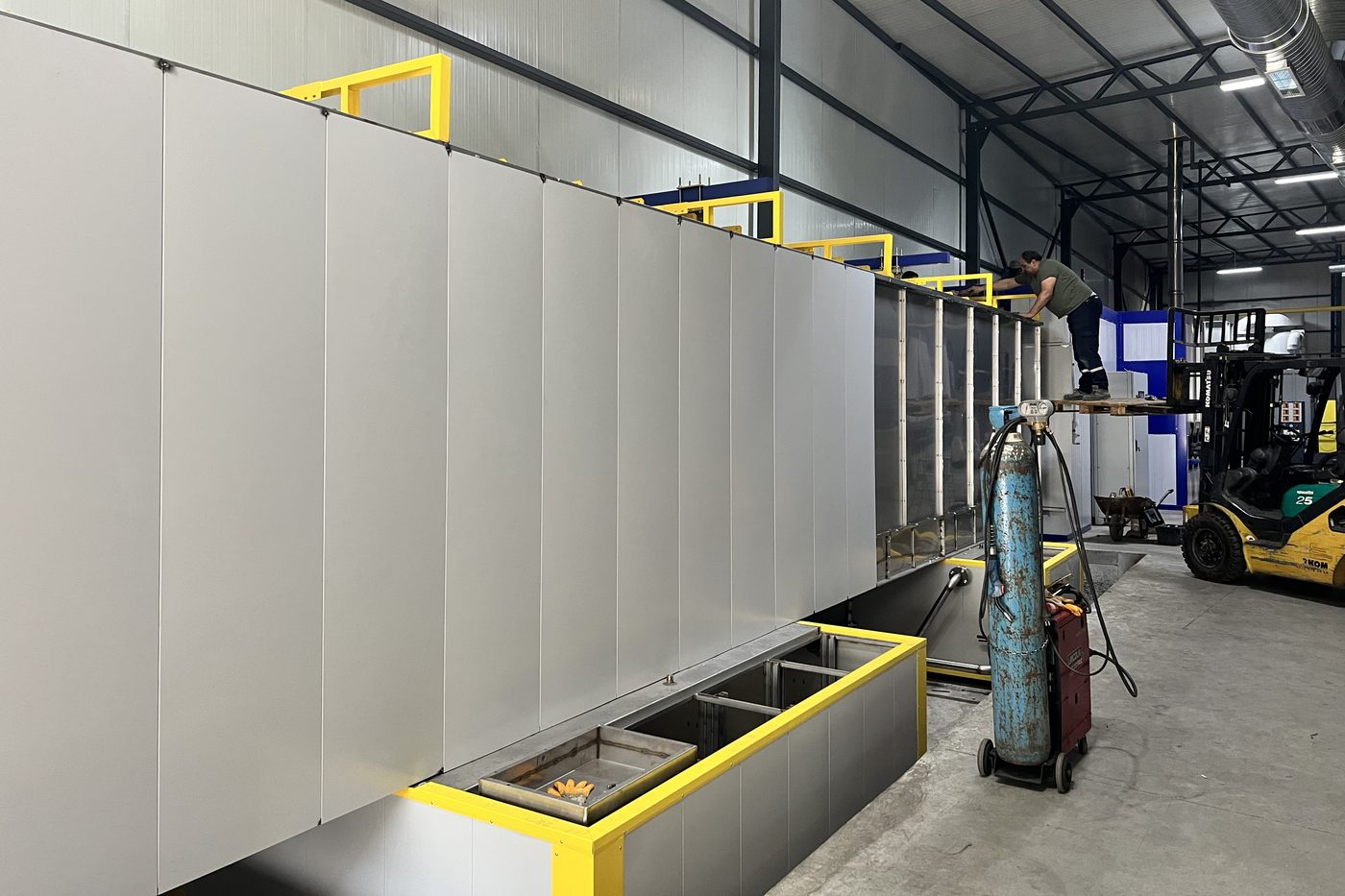 White panelled tunnel and yellow conveyor rail